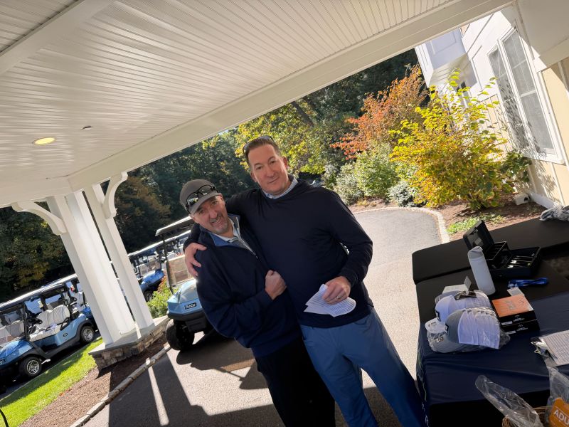 Two golfers at the Kev Classic outside the Needham Golf Club clubhouse